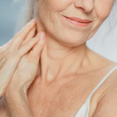 Close up of mature woman’s neck and lower face showing smooth skin and natural texture after anti-wrinkle treatment