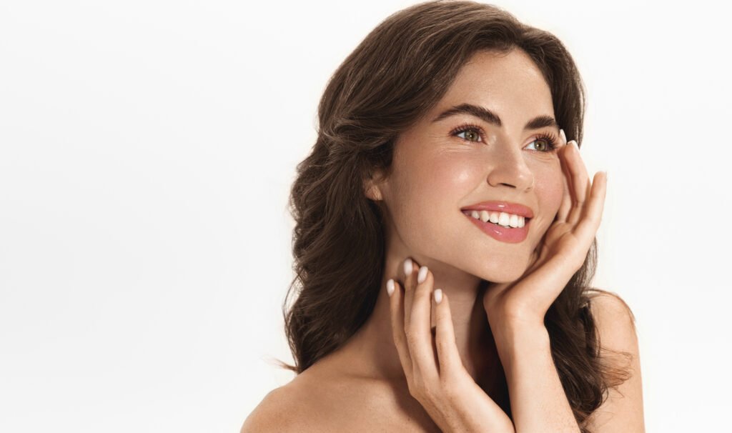Woman smiling and looking to the side with smooth skin and refined facial contours after dermal filler treatment